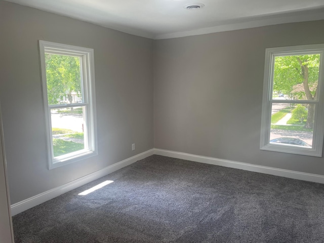 309 4th St, Marshall, MN 56258 - unfurnished room featuring dark colored carpet, healthy amount of natural light, and baseboards
