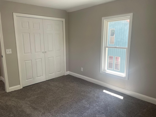 309 4th St, Marshall, MN 56258 - unfurnished bedroom featuring dark carpet, a closet, and baseboards