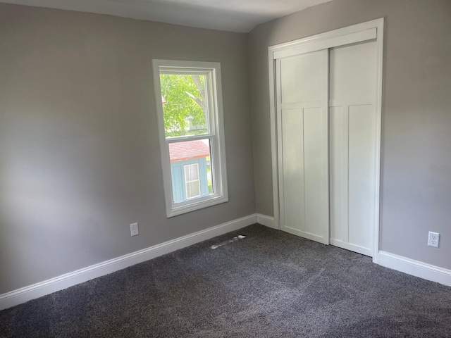309 4th St, Marshall, MN 56258 - unfurnished bedroom featuring dark carpet, baseboards, and a closet