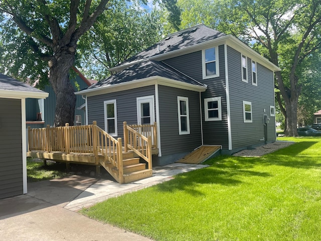309 4th St, Marshall, MN 56258 - back of property featuring a wooden deck, a lawn, and roof with shingles