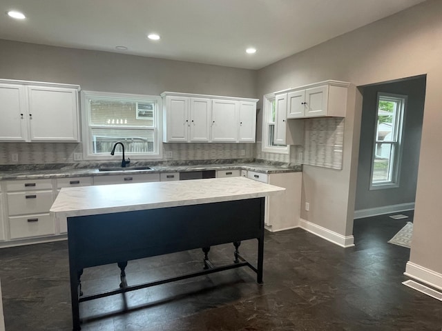 309 4th St, Marshall, MN 56258 - kitchen with a sink, backsplash, baseboards, white cabinets, and recessed lighting