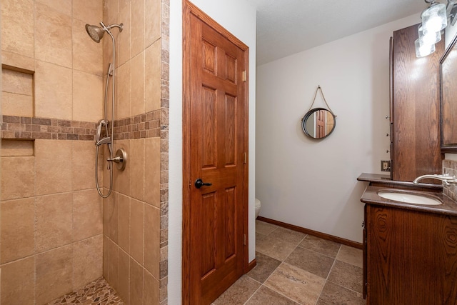 100 Hill Dr, Lime Twp, MN 56001 - bathroom featuring tiled shower, vanity, toilet, and baseboards