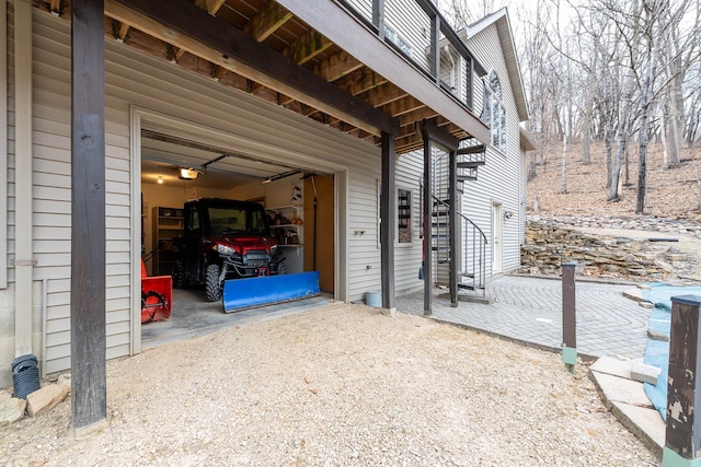 100 Hill Dr, Lime Twp, MN 56001 - view of patio featuring a garage, stairs, and driveway