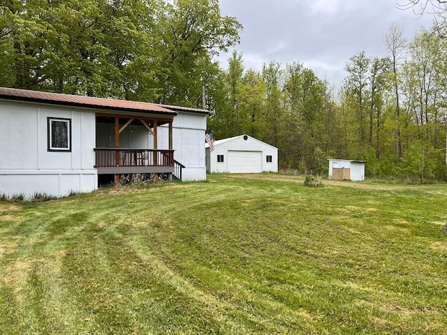 11216 State Highway 27, Beaver Twp, MN 55783 - view of green lawn with a detached garage, an outbuilding, and a porch