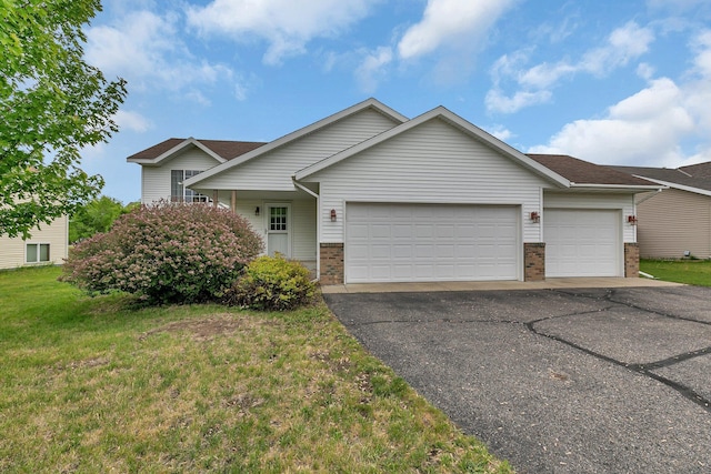 view of front of home with a garage, asphalt driveway, brick siding, and a front yard