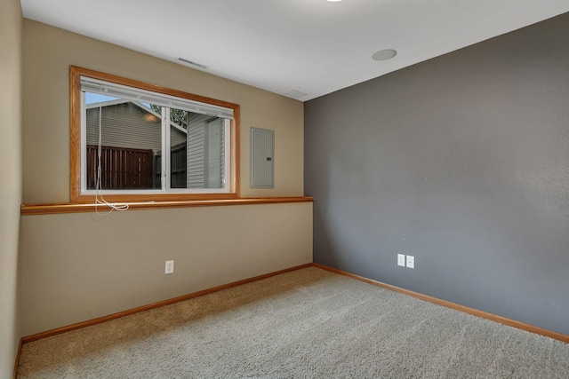 carpeted empty room featuring electric panel and baseboards