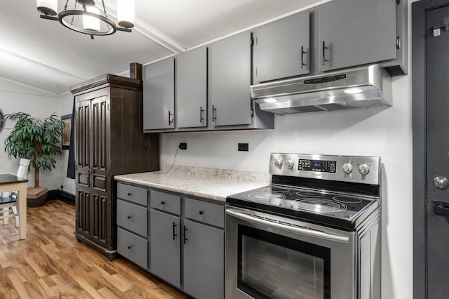750 Prairie Ave SE, Cokato, MN 55321 - kitchen with under cabinet range hood, electric stove, gray cabinets, vaulted ceiling, and light wood-style floors