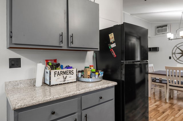750 Prairie Ave SE, Cokato, MN 55321 - kitchen featuring freestanding refrigerator, gray cabinetry, light wood-style floors, an AC wall unit, and light countertops