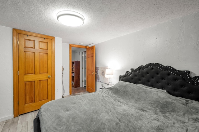 750 Prairie Ave SE, Cokato, MN 55321 - bedroom with light wood finished floors, a textured ceiling, a textured wall, and baseboards