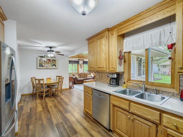 7349 Drew Ave N, Brooklyn Park, MN 55443 - kitchen featuring stainless steel appliances, a sink, light countertops, dark wood-style flooring, and tasteful backsplash