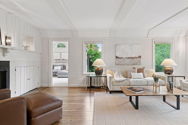 1215 Eleanor Ave, Saint Paul, MN 55116 - living area with wood finished floors, beam ceiling, a brick fireplace, and radiator