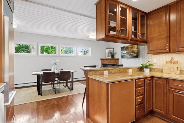 1215 Eleanor Ave, Saint Paul, MN 55116 - kitchen with brown cabinetry, dark wood-type flooring, glass insert cabinets, backsplash, and light stone counters