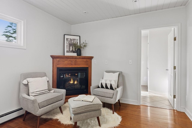 1215 Eleanor Ave, Saint Paul, MN 55116 - living area featuring a baseboard heating unit, a glass covered fireplace, wood finished floors, and baseboards
