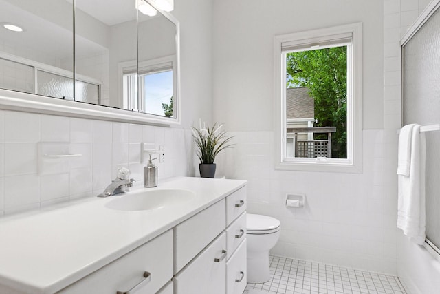 1215 Eleanor Ave, Saint Paul, MN 55116 - bathroom featuring tile walls, tile patterned flooring, vanity, toilet, and a tile shower