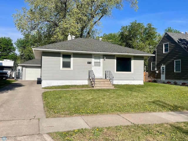 1630 7th St N, Fargo, ND 58102 - bungalow with entry steps, a front lawn, a shingled roof, and an outbuilding