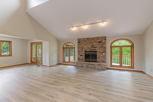 4306 Woods Way, Minnetonka, MN 55345 - unfurnished living room with track lighting, light wood finished floors, baseboards, a fireplace, and high vaulted ceiling