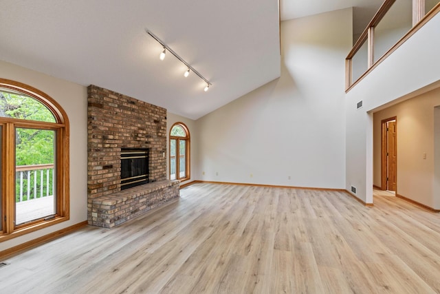 4306 Woods Way, Minnetonka, MN 55345 - unfurnished living room with rail lighting, light wood finished floors, baseboards, and high vaulted ceiling