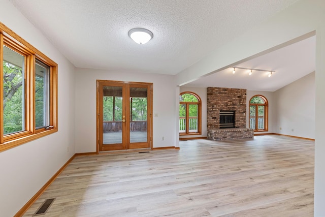 4306 Woods Way, Minnetonka, MN 55345 - unfurnished living room featuring french doors, light wood-style floors, baseboards, a textured ceiling, and track lighting