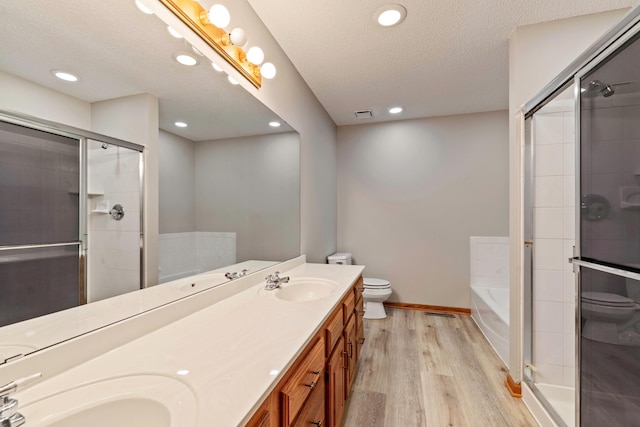 4306 Woods Way, Minnetonka, MN 55345 - full bathroom with wood finished floors, toilet, a shower stall, a garden tub, and double vanity