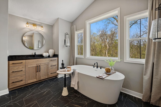 15630 112th St, Dayton, MN 55369 - full bathroom with marble tiled floors, baseboards, healthy amount of natural light, lofted ceiling, and a freestanding tub