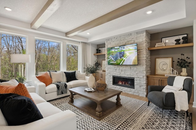 15630 112th St, Dayton, MN 55369 - living room with beam ceiling, wood finished floors, a stone fireplace, and a textured ceiling