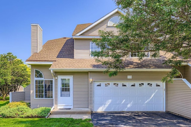 7293 Savanna Ct, Lino Lakes, MN 55014 - traditional home with driveway, roof with shingles, an attached garage, and a chimney