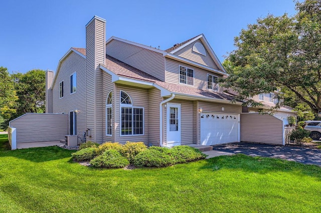7293 Savanna Ct, Lino Lakes, MN 55014 - traditional-style house featuring asphalt driveway, an attached garage, a chimney, a front yard, and a shingled roof