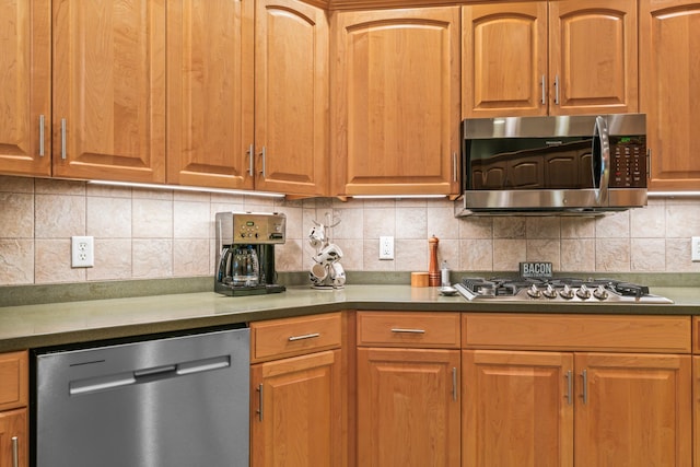 2508 4th Ave NW, Austin, MN 55912 - kitchen featuring stainless steel appliances, decorative backsplash, dark countertops, and brown cabinetry