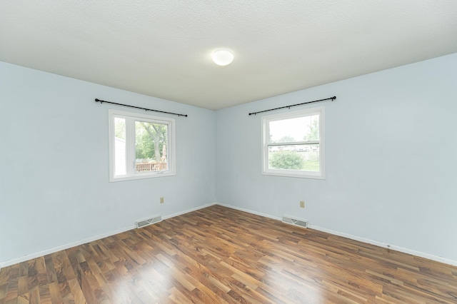 empty room featuring wood finished floors and baseboards
