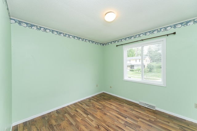 spare room featuring wood finished floors and baseboards