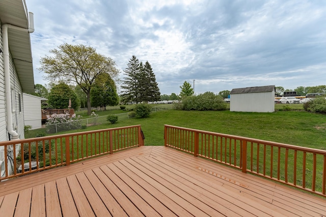 wooden deck featuring a yard, an outbuilding, and a storage unit