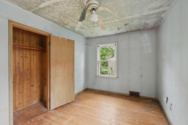 unfurnished bedroom with light wood-type flooring, a closet, and a ceiling fan