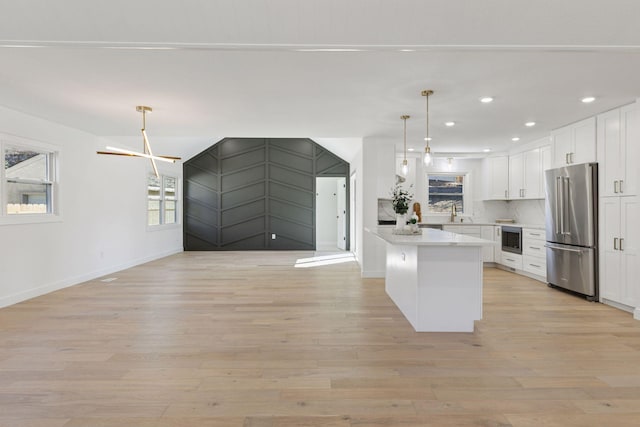 1022 Fairview Ave S, Saint Paul, MN 55116 - kitchen featuring stainless steel appliances, white cabinetry, light wood-type flooring, open floor plan, and recessed lighting
