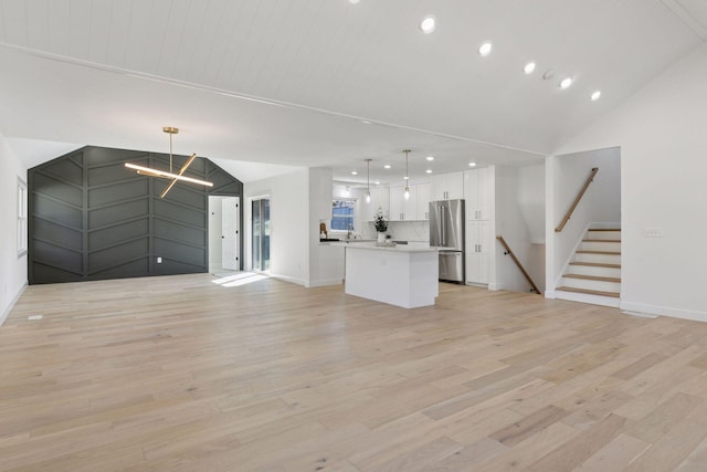 1022 Fairview Ave S, Saint Paul, MN 55116 - unfurnished living room with recessed lighting, light wood-style floors, vaulted ceiling, a chandelier, and baseboards