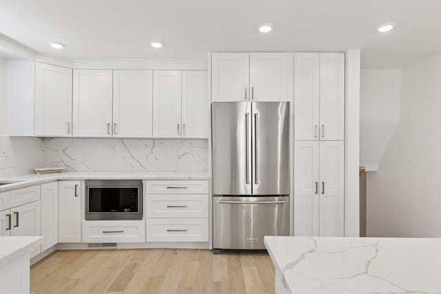 1022 Fairview Ave S, Saint Paul, MN 55116 - kitchen with appliances with stainless steel finishes, white cabinetry, light stone counters, light wood-style floors, and recessed lighting