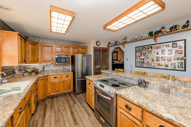 28040 Anchor Rd, Detroit Twp, MN 56501 - kitchen featuring appliances with stainless steel finishes, a sink, wood finished floors, and brown cabinetry