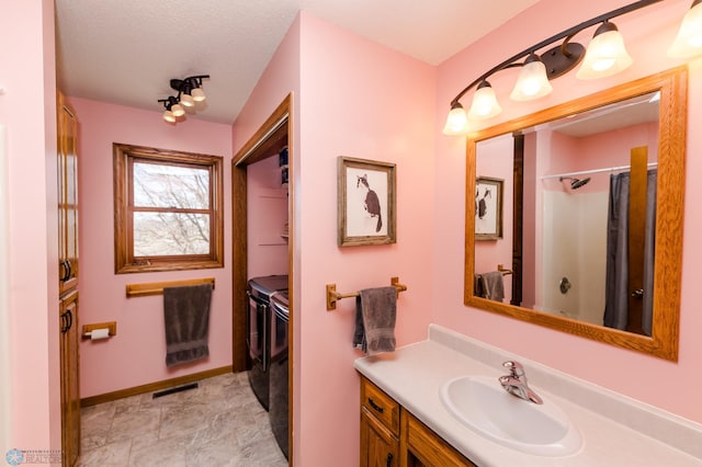 28040 Anchor Rd, Detroit Twp, MN 56501 - bathroom with separate washer and dryer, vanity, curtained shower, and baseboards
