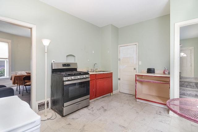 1430 Penn Ave N, Minneapolis, MN 55411 - kitchen featuring stainless steel range with gas cooktop, light marble finish floors, light countertops, and a sink
