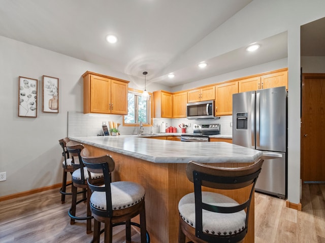 509 Kinkead Dr NW, Alexandria, MN 56308 - kitchen featuring appliances with stainless steel finishes, a peninsula, light countertops, backsplash, and lofted ceiling