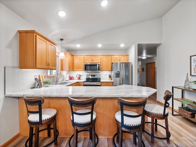 509 Kinkead Dr NW, Alexandria, MN 56308 - kitchen featuring appliances with stainless steel finishes, light countertops, vaulted ceiling, a peninsula, and baseboards