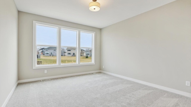 carpeted empty room featuring baseboards