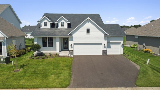 traditional home with driveway, a front yard, and a shingled roof
