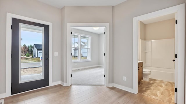 foyer entrance with light wood finished floors and baseboards