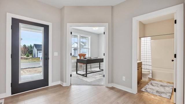 entrance foyer featuring light wood finished floors and baseboards