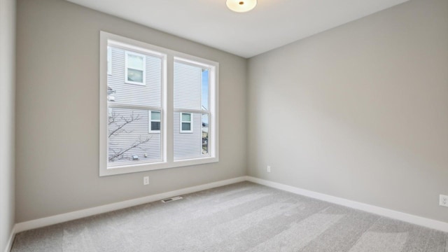carpeted spare room featuring baseboards