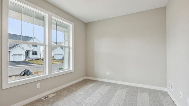 spare room featuring carpet flooring and baseboards