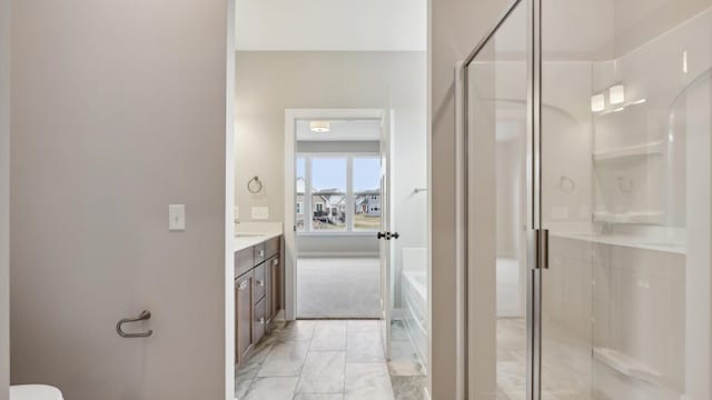 full bath featuring a stall shower, marble look tile flooring, vanity, and a bath