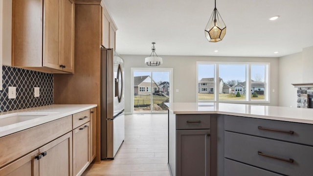 kitchen with stainless steel fridge, gray cabinetry, backsplash, light countertops, and recessed lighting