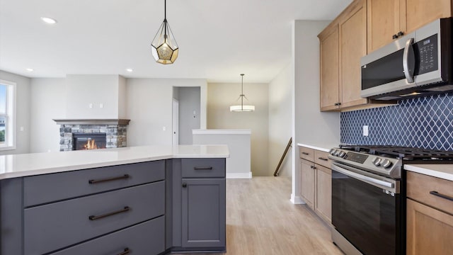 kitchen featuring stainless steel appliances, tasteful backsplash, light wood-type flooring, light countertops, and recessed lighting