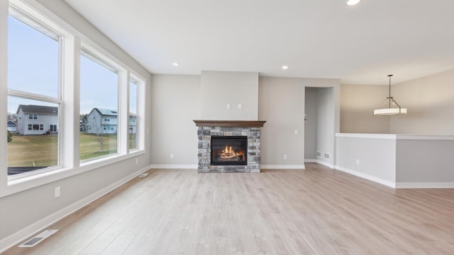 unfurnished living room featuring light wood-style floors, a fireplace, baseboards, and recessed lighting